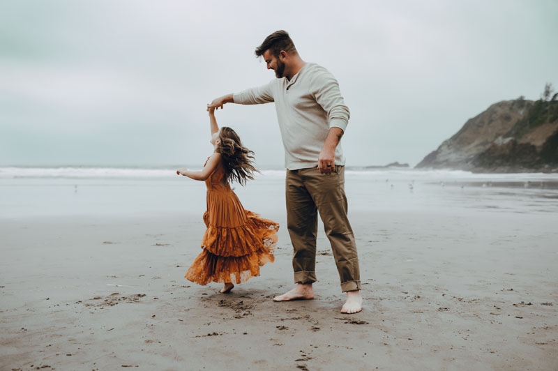 dad twirling daughter during session with Oregon Coast Photographer