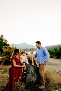 Portland Family Photographer, mom and dad are outside as their two boys sit on a large rock
