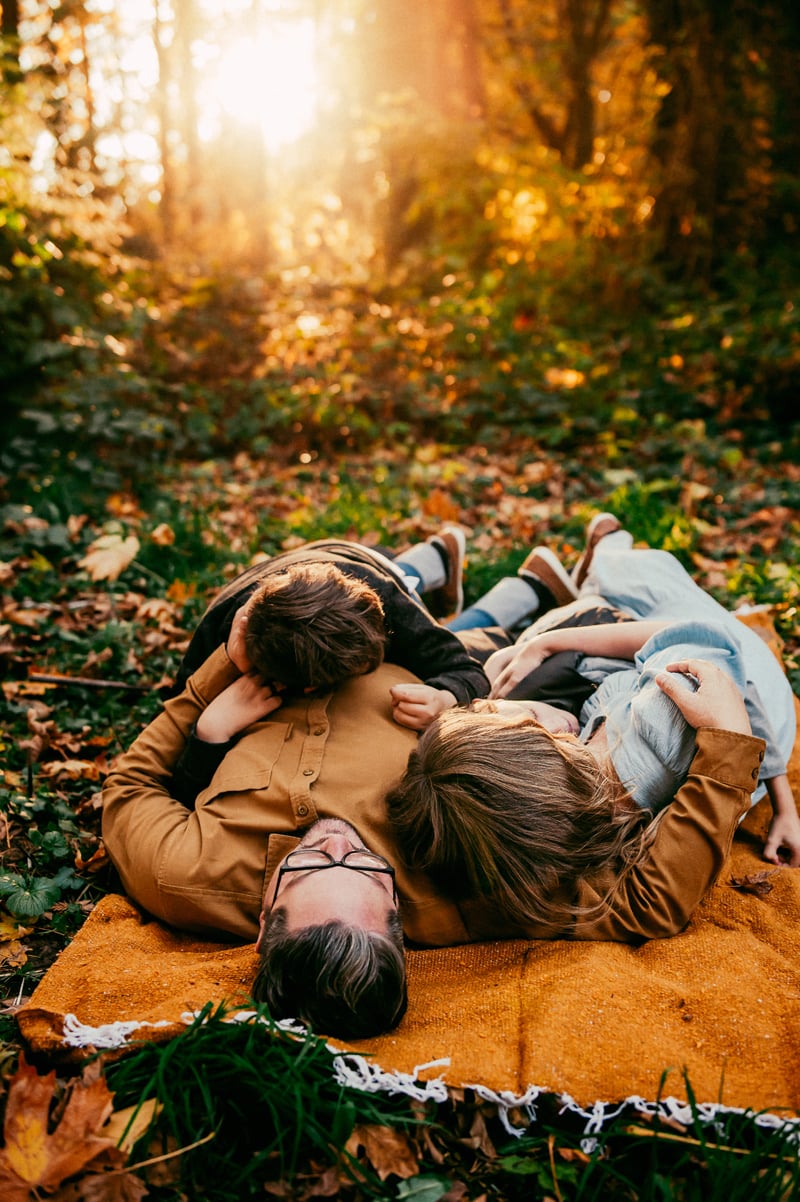 Portland Family Photography, a family lays down on a blanket in the forest