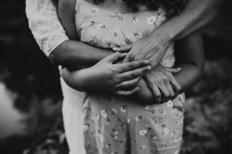 detail photo of mother's hands over daughter's