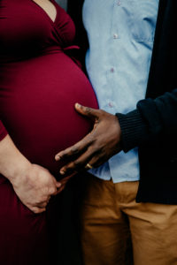 Maternity and Newborn Photography, a man places his hand on his wife's pregnant belly, she is expecting soon