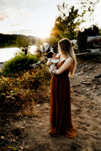 mom holds baby at a park in oregon city during newborn photoshoot
