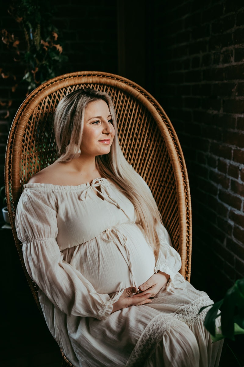 expecting mom sitting on a wicker chair