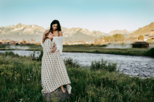 mother and daughter hugging in the morning light with mountains in the backdrop