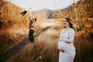 PREGNANT WOMAN DURING MATERNITY SESSION AT COLUMBIA RIVER GORGE WEARING VIOLET DRESS