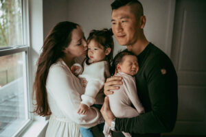 family of four being photographed for a newborn session in washington