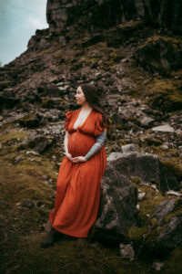 pregnant woman in a red dress posing at columbia river gorge for maternity session