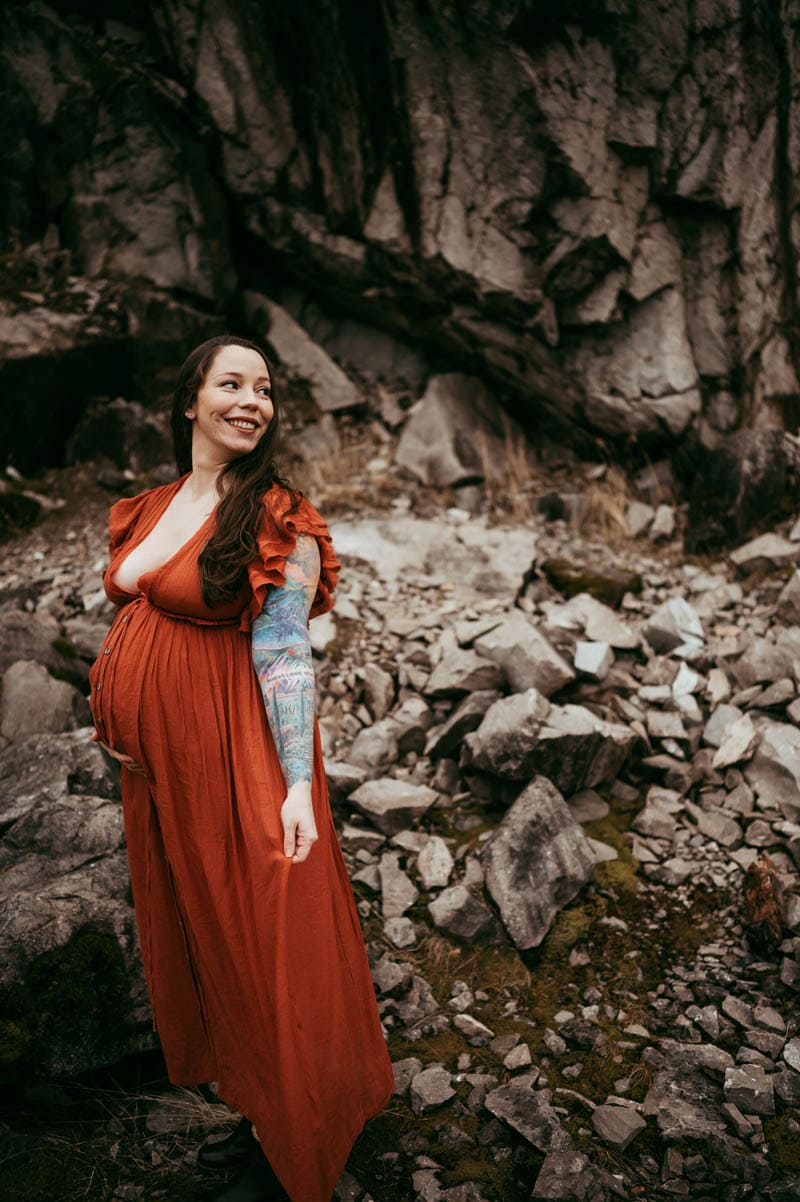 pregnant woman in a red dress posing at columbia river gorge for maternity session - portland midwife